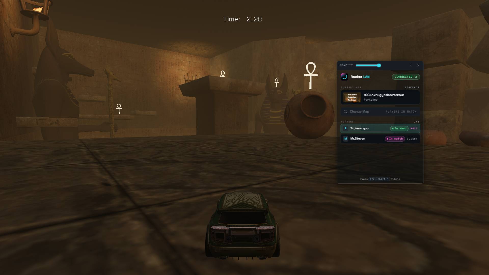 In-game Rocket League screenshot on an Egyptian parkour custom map; the Rocket LAN overlay floats at the top-right showing current map, two connected players, and their match/menu status.